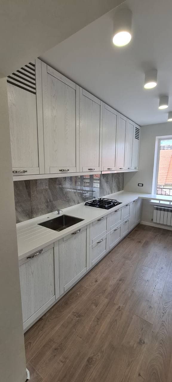 Bucătărie lungă cu fronturi în decor de lemn